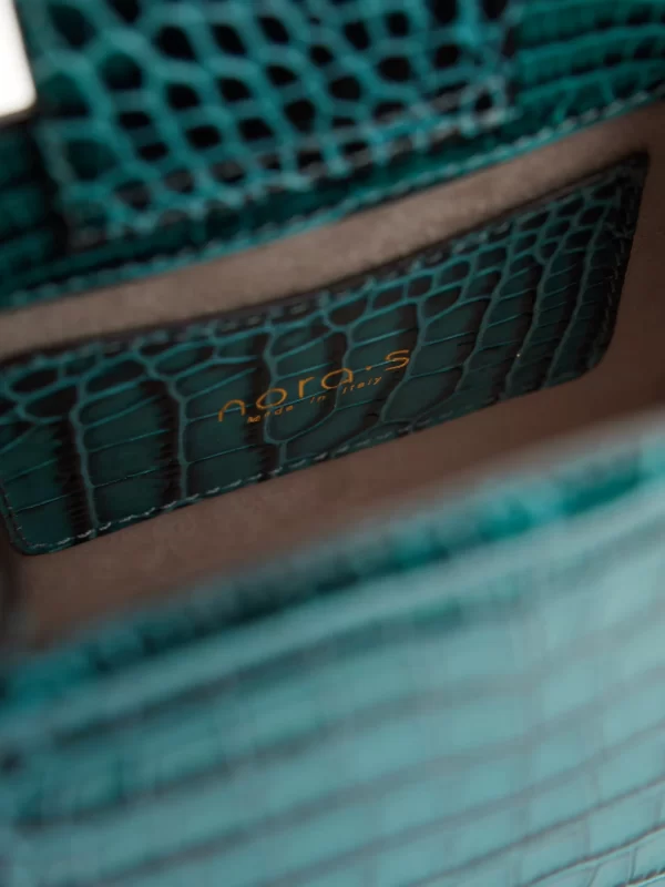 A beautifully handcrafted Italian leather handbag carefully made using a unique vintage washed process giving it an outstanding finish. This luxurious classy small bag with golden details closed with a golden button has a croco print and the front flap is made out of fake fur. Inside there is an extra compartment that closes with a zipper and there is a long handle to carry the bag with you.