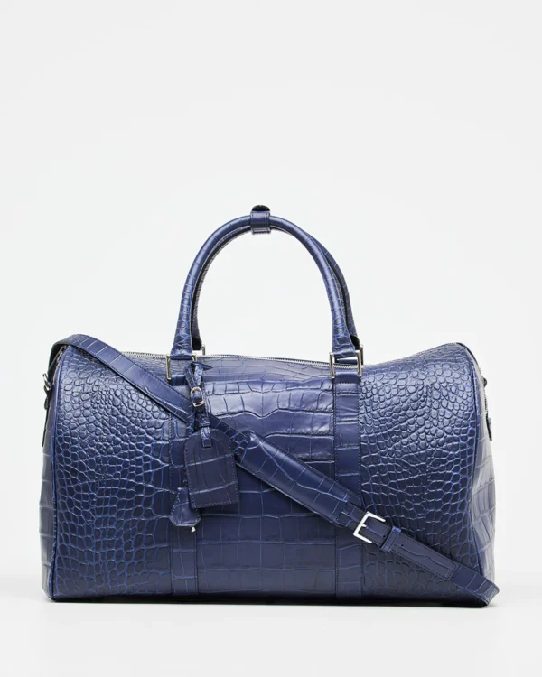 This stunning leather weekend travel bag is perfect for your next getaway. It features a Croco print that adds a touch of luxury and elegance. The roomy interior is perfect for packing all your essentials, and the adjustable strap makes it easy to carry. This classy duffle bag handmade in Italy with Tuscany calf leather and high-quality materials is completed with zipped compartments and card pockets.